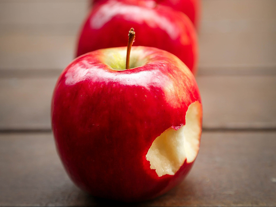 Im Schreibbüro angebissener roter Apfel